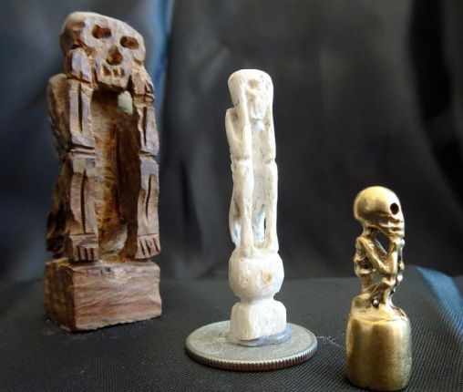 Imagens de San La Muerte feitos respectivamente de madeira, osso humano e projetil.